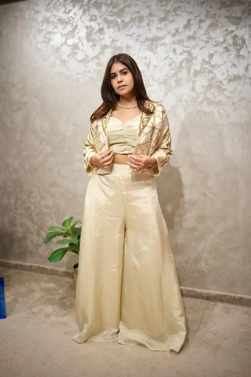 Woman wearing a cream-colored outfit with a textured wall background